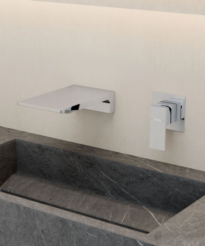 Mitigeur lavabo mural cascade Chromé - Thilia, installé au-dessus d'une vasque en pierre noire